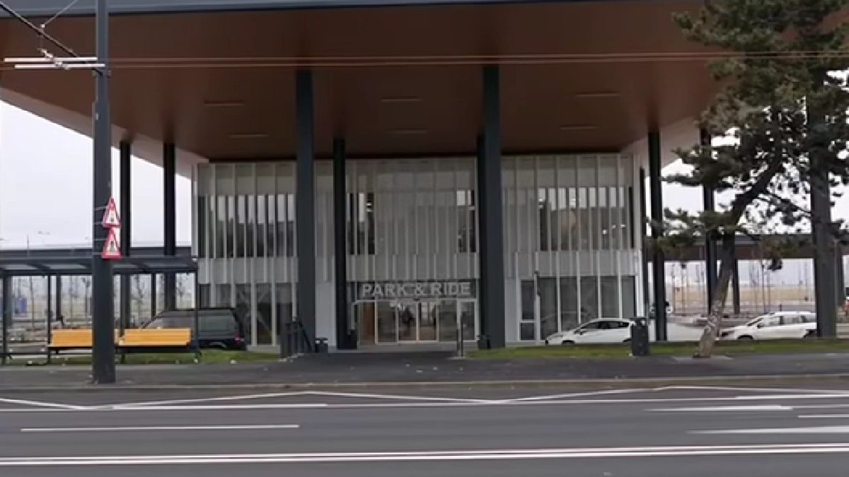 Intrarea în parcarea de langa aeroportul din Cluj, două mașini albe și una neagră sunt parcate în fața parcării