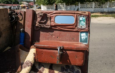 In stânga sa se găseşte o oglinda mică, o iconiţă de carton cu Arsenie Boca şi o cutie închisă cu lacăt