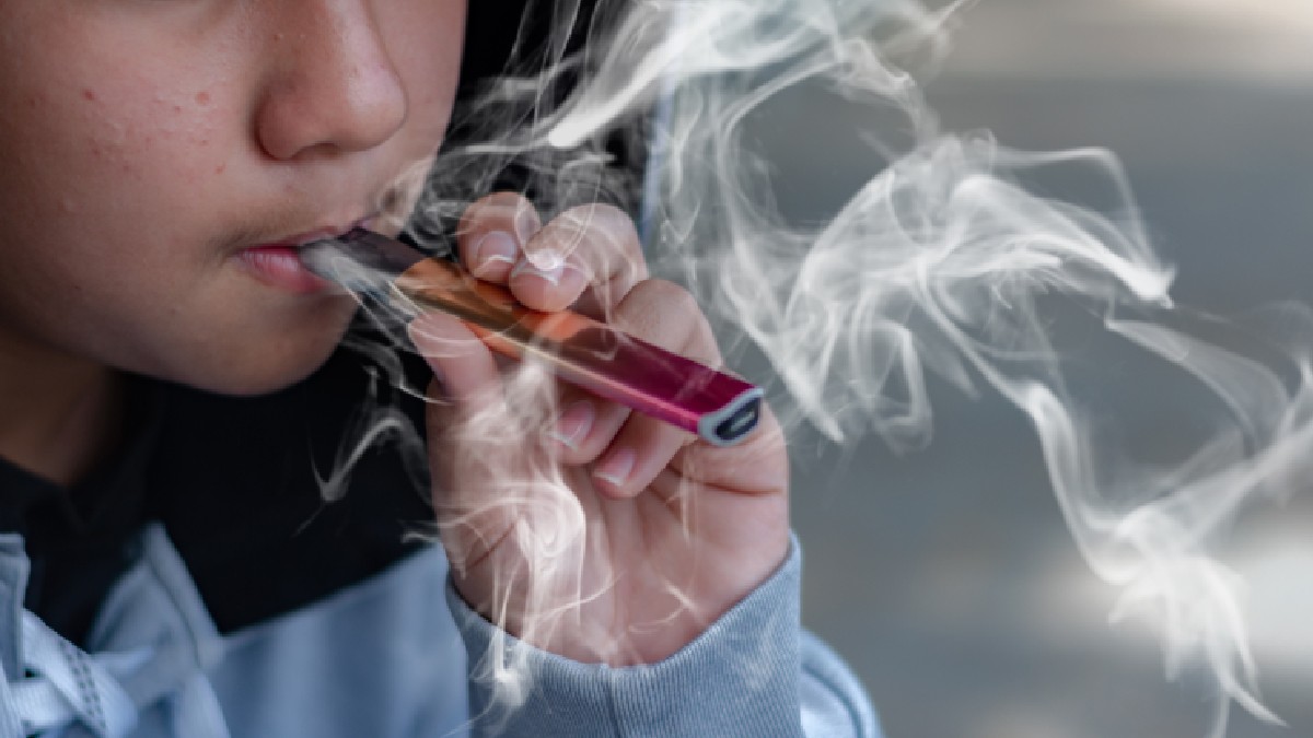 Un copil ține în mână o machetă din plastic care seamănă cu o țigară electronică