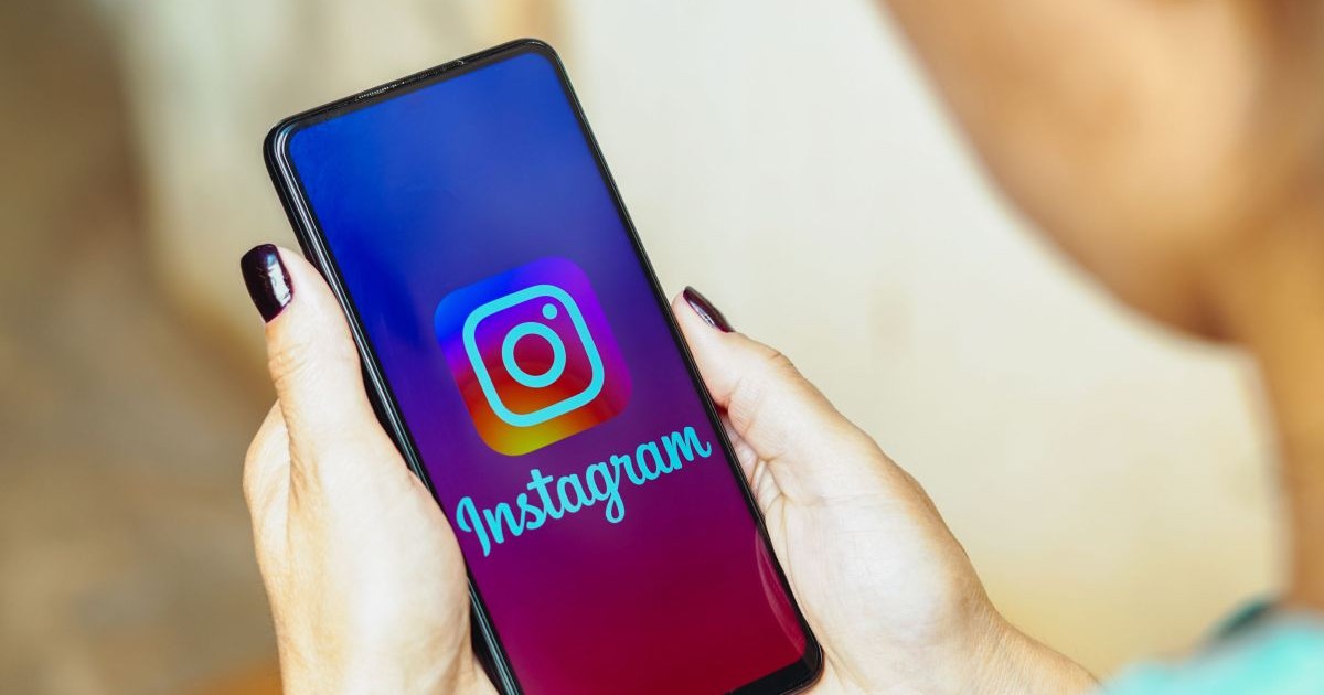 o femeie ține în mână un telefon pe care este deschisă aplicația Instagram