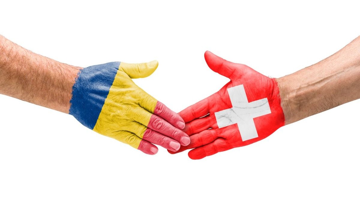 Imagine creativă cu două mâini care dau noroc, una desenată în steagul României, iar alta în steagul Elveției