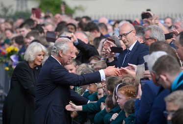 Regele Charles al III-lea și regina consoartă Camilla salută mulțimea adunată la Castelul Hillsborough din Irlanda de Nord. Foto: EPA