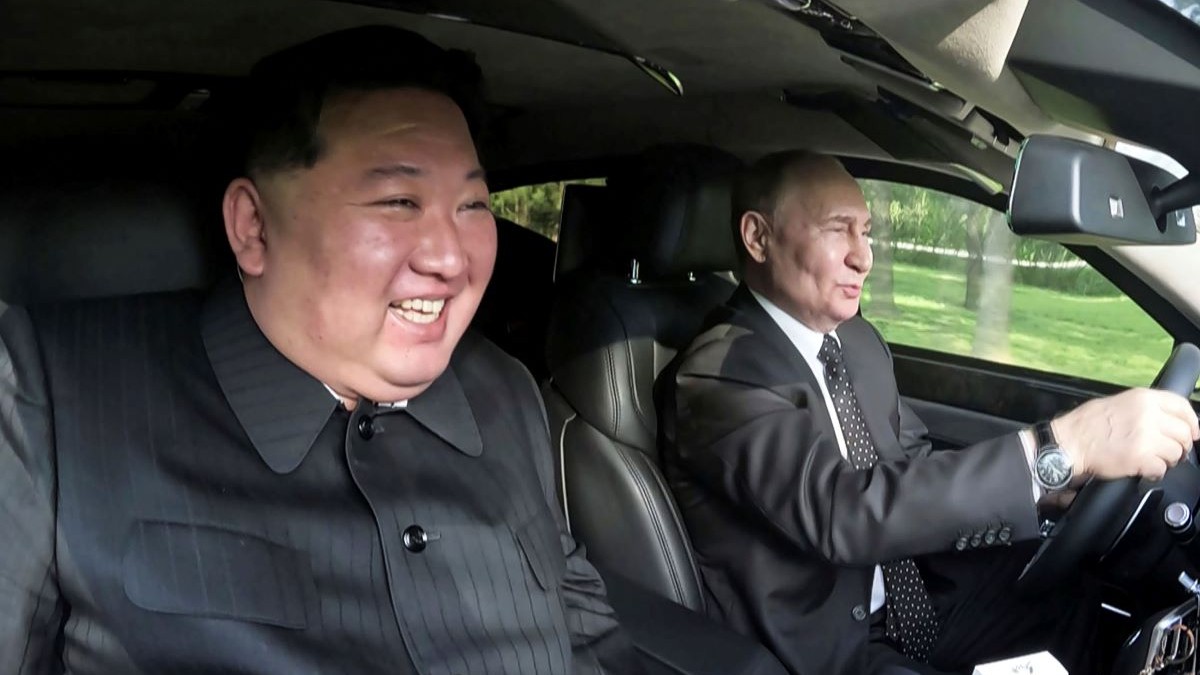 Vladimir Putin și Kim Jong-un cu zâmbetul pe buze, într-o mașină condusă de liderul rus