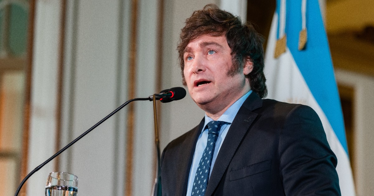 Javier Milei în costum negru în timp ce vorbește la microfon