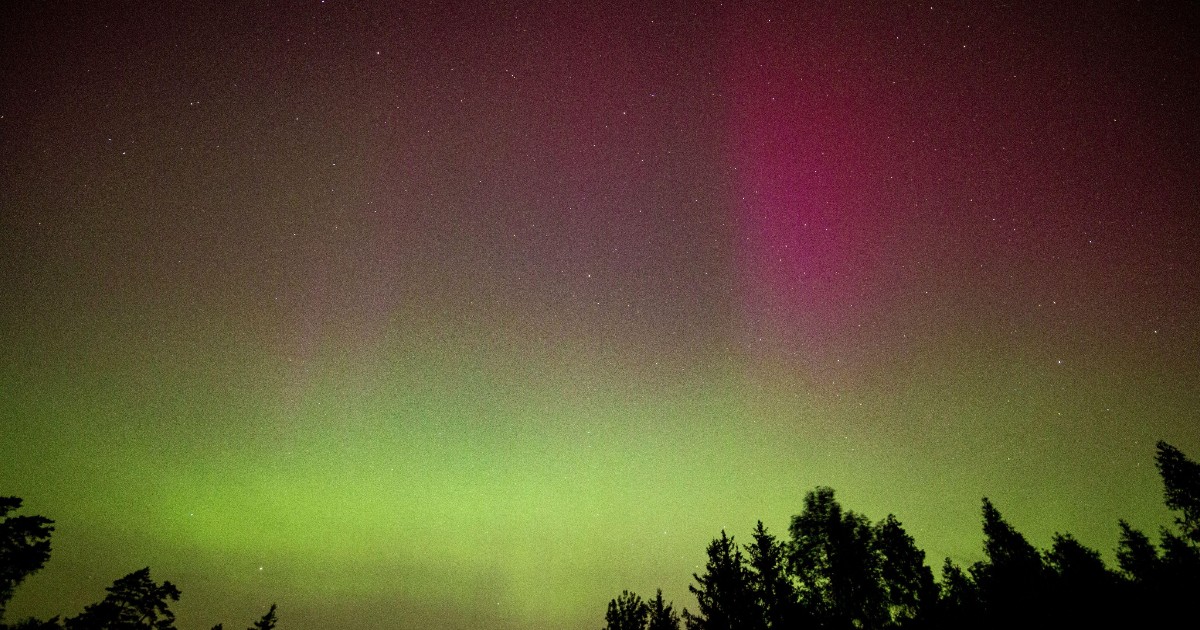 O auroră boreală în care se observă culorile verde și roz