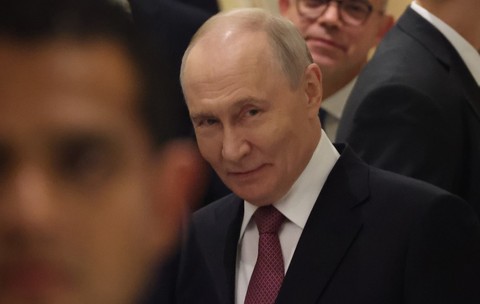 Vladimir Putin, în timpul unui eveniment oficial. Este înconjurat de oameni și poartă un costum albastru