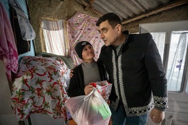 Simion consolează o mamă care şi-a pierdut copilul, din comuna Găgeşti