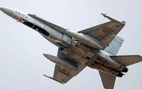 Imaginea prezintă partea inferioară a unui avion de vânătoare F/A-18 Hornet al Forțelor Aeriene Spaniole în timpul zborului pe cer.