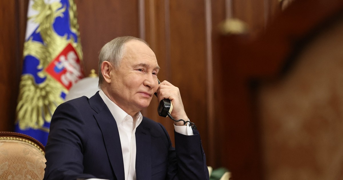 Vladimir Putin surprins în timp ce vorbește la telefon.