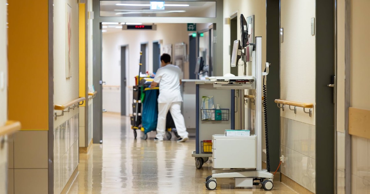 această fotografie arată un hol lung, bine iluminat și impecabil de curat, dintr-o unitate medicală modernă. Podeaua lucioasă reflectă lumina din jur și subliniază standardele înalte de igienă, indispensabile în domeniul sănătății.