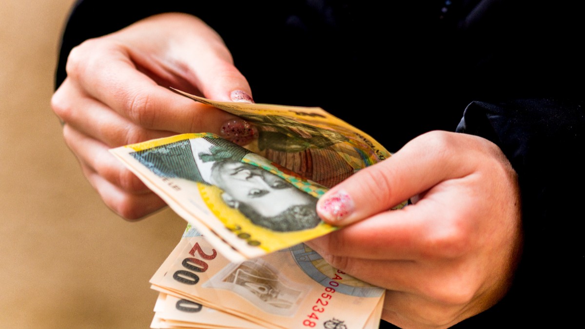 O femeie care numără bancnote în lei
