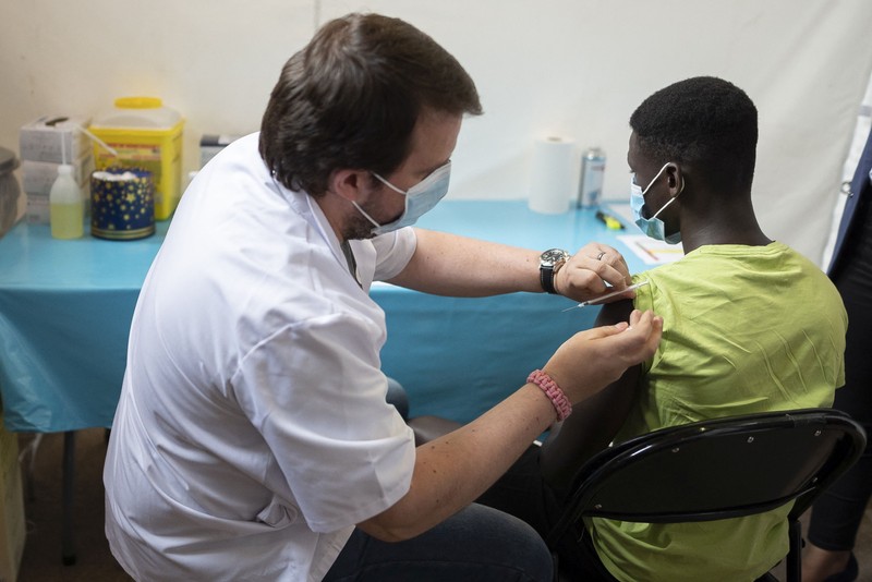 Un adolescent primește un vaccin anti-COVID-19 pe 24 august 2021 în Argenteuil, la nord de Paris | Foto: Hepta
