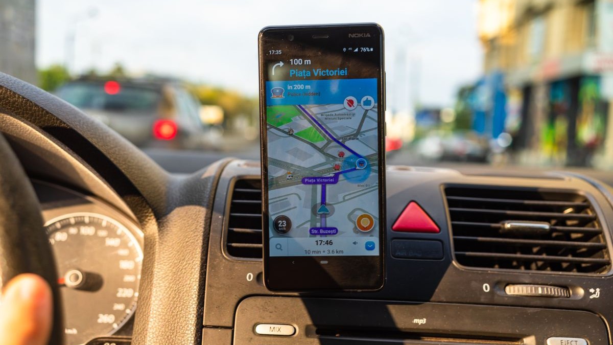 Telefon cu aplicația Waze deschisă, care arată o alertă de poliție în Piața Victoriei din București, montat pe bordul unei mașini