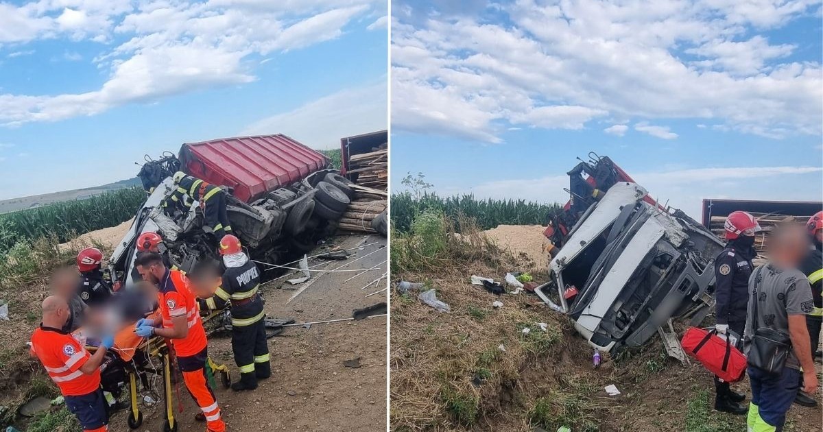 camion roșu cu remorcă, răsturnat pe marginea drumului. cabina camionului este grav avariată și înclinată e o parte, iar remorca este răsturnată, cu lemne care s-au împrăștiat pe marginea drumului. În apropierea cabinei camionului se află mai mulți salvatori și pompieri sunt în jurul unui pacient pe targă. Aceștia poartă echipamente de protecție: uniformă portocalie cu dungi reflectorizante pentru paramedici și uniforme negre cu galben pentru pompieri.