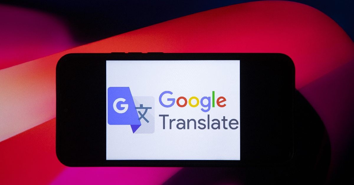 Logo-ul Google Translate, deschis pe ecranul unui telefon așezat pe un fundal roșu cu negru.