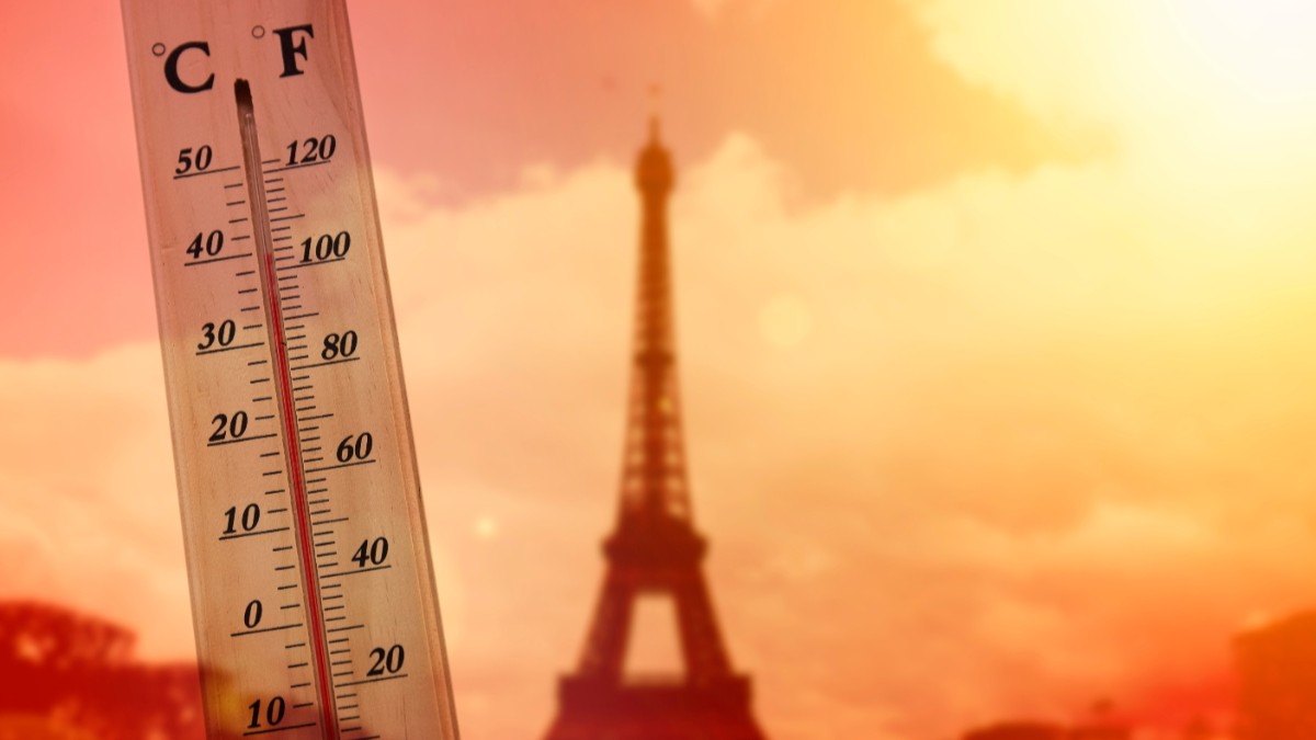 În Imagine este ilustrate un termometru ce indică o temperatură ridicată și silueta estompată a Turnului Eiffel din Paris sub un cer canicular în nuanțe aprinse de portocaliu și roșu.