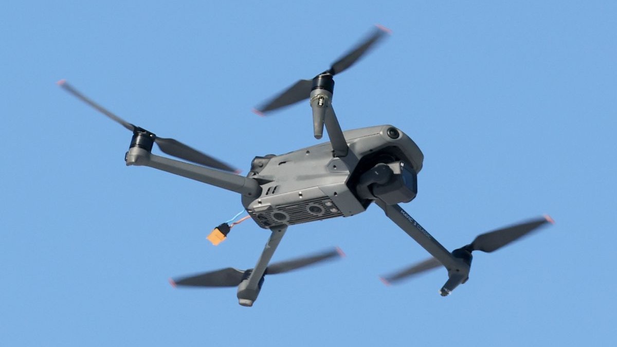 O dronă militară zboară pe fundalul unui cer albastru și senin