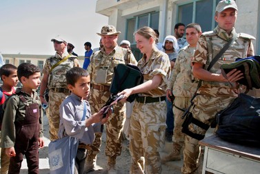 Soldați români și britanici distribuie ghiozdane pentru copiii afgani lângă Kabul. FOTO EPA