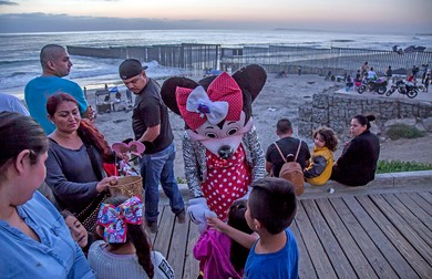 Migranți așteaptă să treacă granița dintre Mexic și Stalele Unite între Tijuanaspre și San Diego. Foto Northfoto
