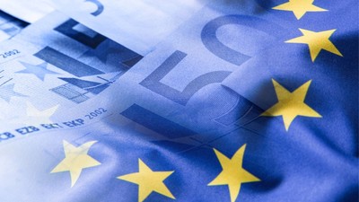 _Steagul Uniunii Europene fluturând pe un fundal cu monede euro.