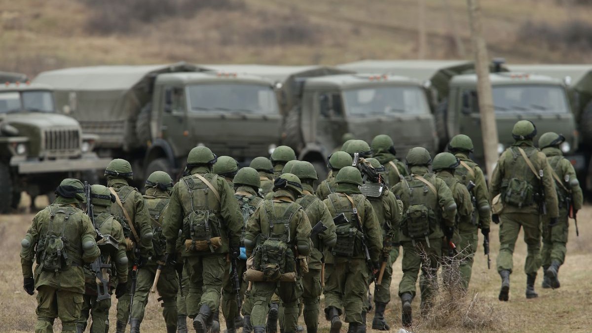 Un grup de militri ruși se îndreaptă către mai multe camioane parcate în apropiere, 2 martie 2014