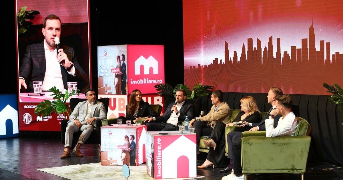 Dezvoltatori imobiliari, care stau pe scaune, în platoul Imobiliare.ro HUB Național 2025, pe fundal roșu, cu logo-ul Imobiliare.ro