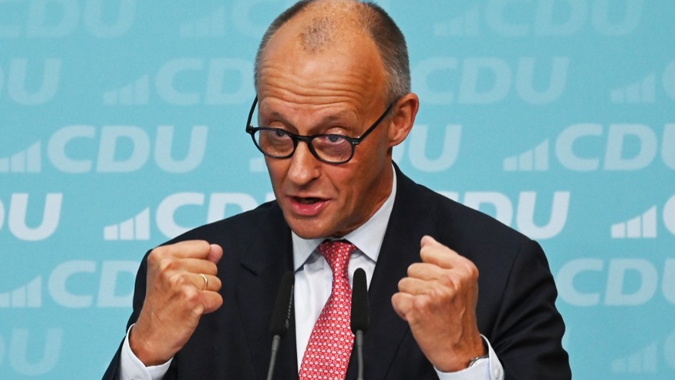 Cancelarul german Friedrich Merz vorbind gesticulând cu ambii pumni strânși în fața unui fundal cu sigla partidului CDU