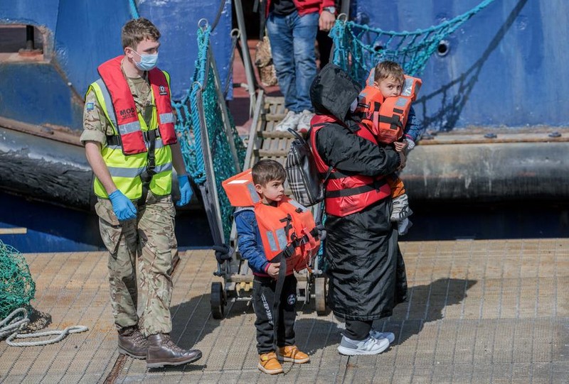 Migranți escortați de militarii britanici după ce au trecut Canalul Mânecii și au ajuns în Marea Britanie, 15 April 2022 | Foto EPA