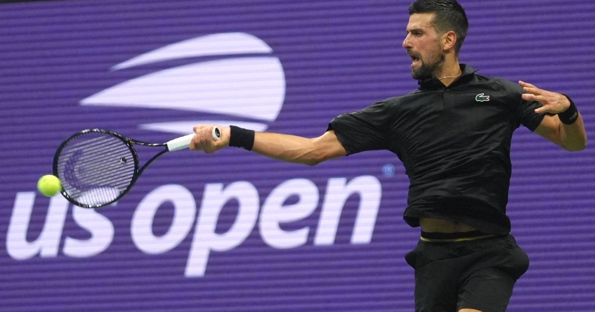 Novak Djokovic, îmbrăcat în negru, surprins returnând o minge în timpul unui meci la US Open, august 2025