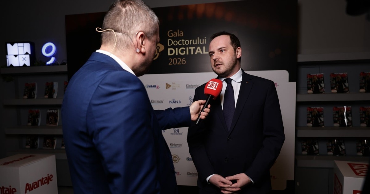 Dorin Chioțea, îmbrăcat în costum albastru închis și Alexandru Rogobete în timp ce oferă un interviu.