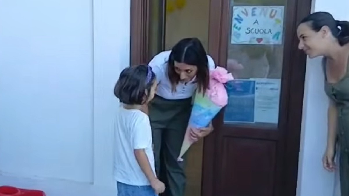 O fetiță intră în sala d eclasa, in Italia, fiind intampinata de profesoara sa