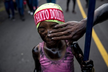 O fetiță este pictată cu ulei negru în timpul procesiunii în cinstea lui Santo Domingo de Guzman, în Managua, Nicaragua, 1 august 2022. Ritualul a fost reluat după o pauză de 3 ani din cauza pandemiei Covid-19,