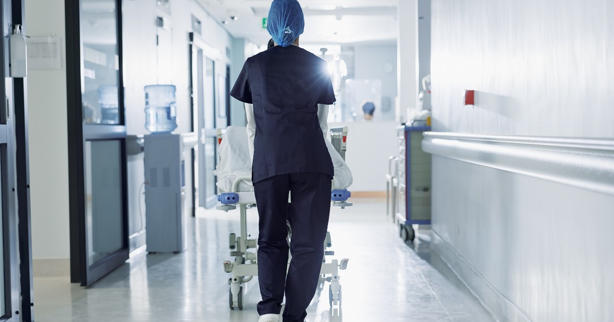 Un grup de asistente medicale care plimbă un pat de spital