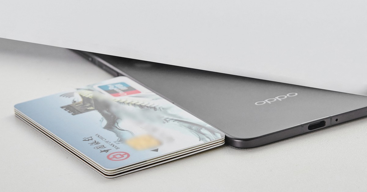 Un smartphone pliabil Oppo Find N5 așezat lângă câteva carduri bancare pentru a putea fi demonstrată subțirimea sa.