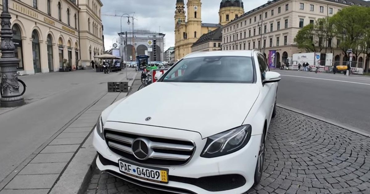 Mercedes E-Class diesel, de culoare albă, înmatriculat în Germania, pe o stradă din Munchen, cu piatră cubică pe jos