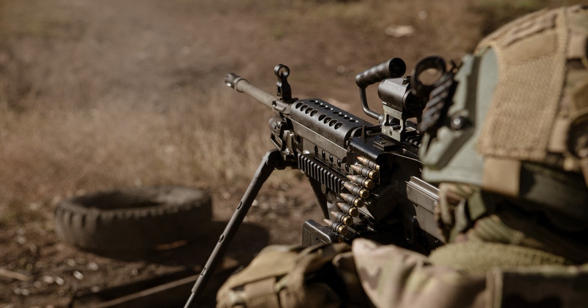 Soldat care trage cu o mitralieră de fabricație americană, M249 SAW.