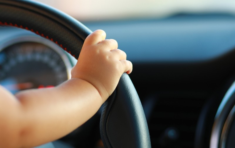 Mamă surprinsă pe autostradă în timp ce copilul de 1 an ținea volanul, iar ea scria pe telefon