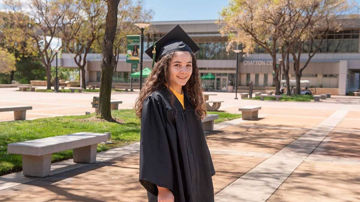 Poză cu Alisa Perales care poartă roba și toca de absolvire a facultății