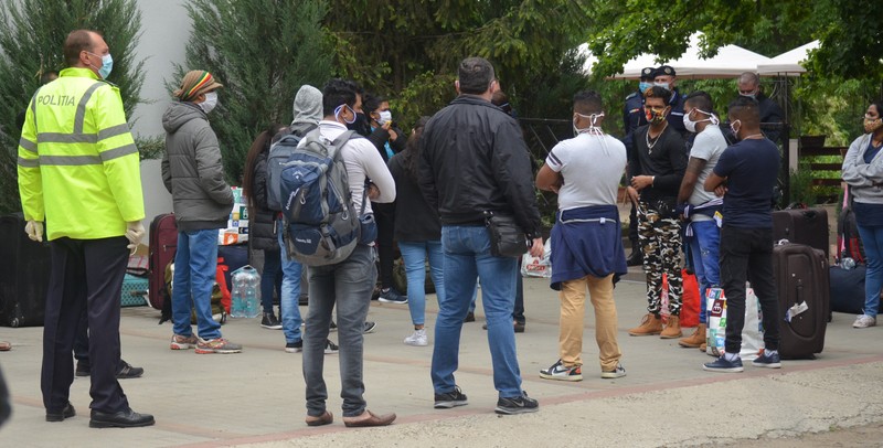Muncitorii srilankezi au avut o discuție cu jandarmii înainte să fie îmbarcați în autocare spre București FOTO: Răzvan Luțac
