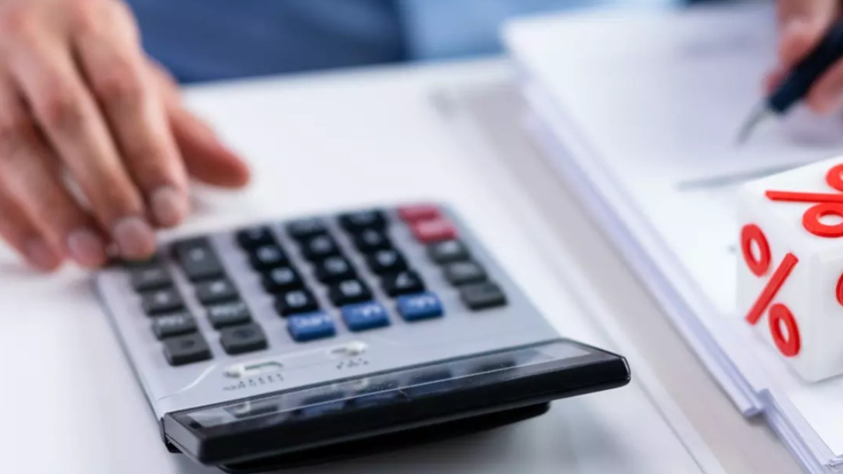 Un bărbat care face calcule pe un calculator de birou