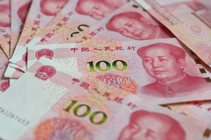 Bancnote de 100 de yuani chinezești zac pe o masă. FOTO: Hepta.
