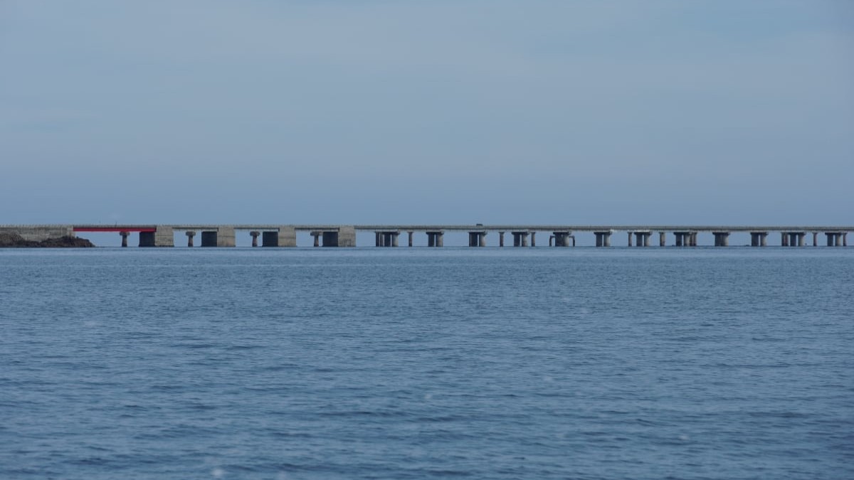 Vedere panoramică asupra mării. O construcție de beton pe piloni se vede peste apele canalului.