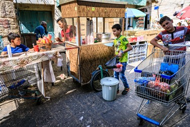 Pe o stradă comercială din Betleem mai mulți copii își ajută părinții la activitățile zilnice