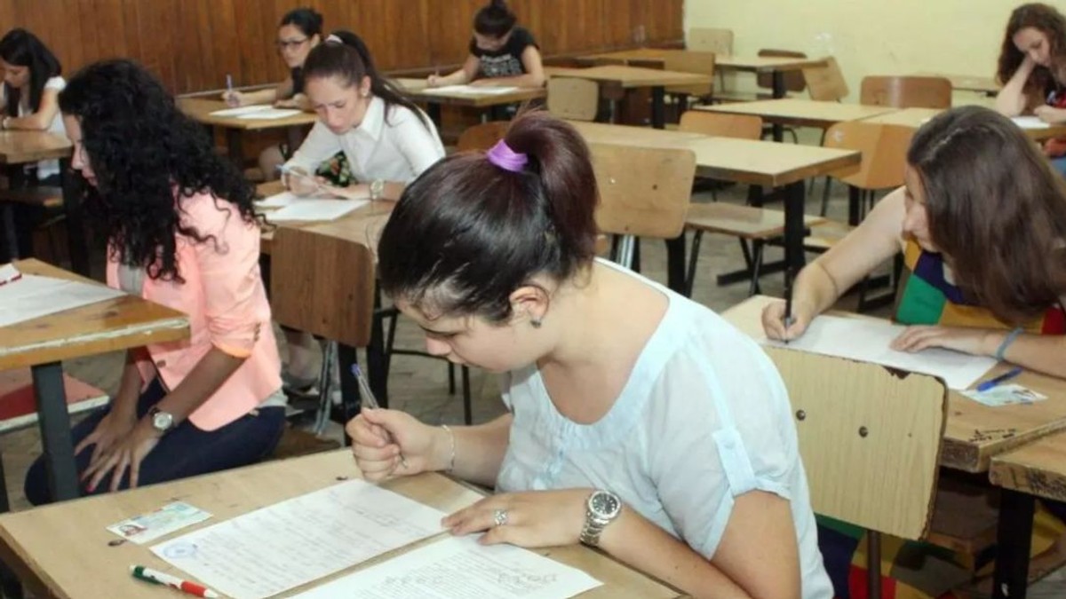 Elevi de liceu în bănci în timp ce completează un test