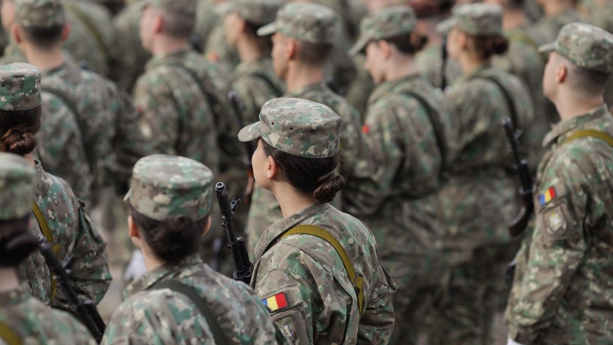 Militari români, femei și bărbați, îmbrăcați în uniforme militare