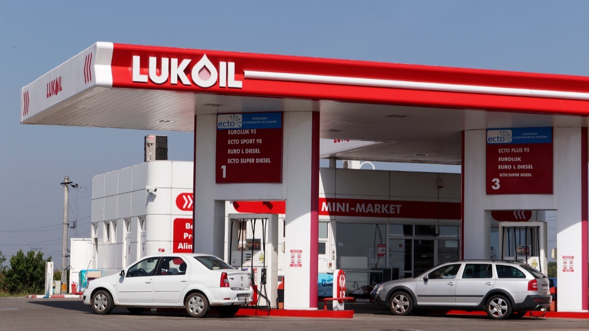 O benzinărie Lukoil din România, mașinile sunt așezate la pompă și șoferii alimentează