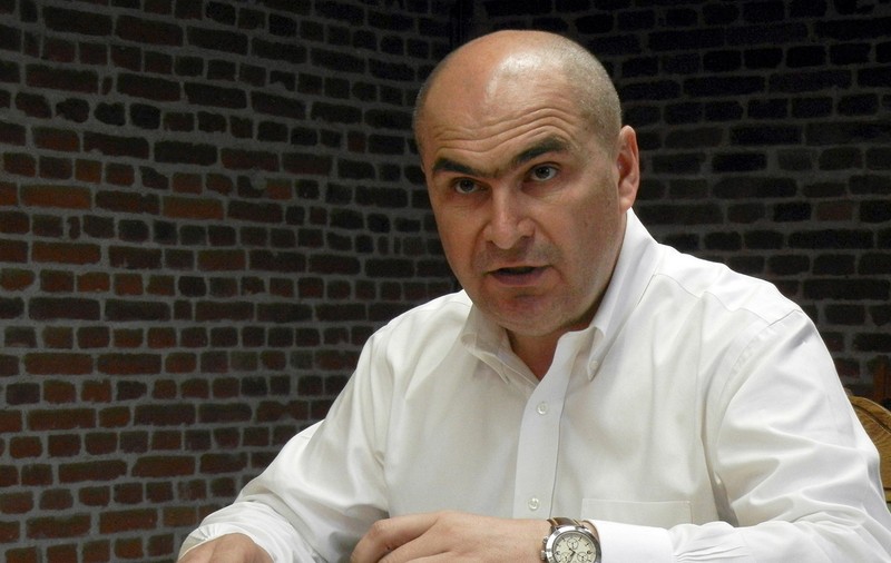 „Câinele moare de drum lung și prostul…” Inscripția care l-a șocat pe liberalul Bolojan când a văzut-o vopsită pe peretele din biroul unui director din minister