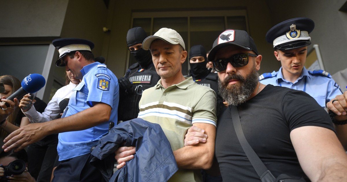 Un barbat incatusat este scos de pilotisti din sediul DIICOT