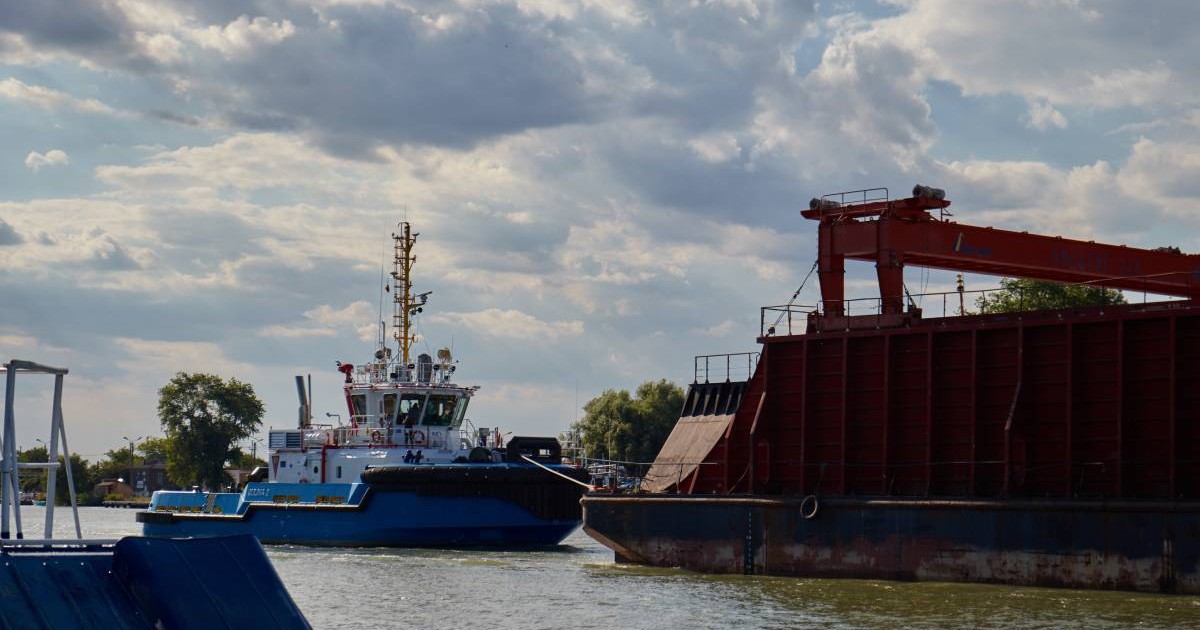 O barcă cu turiști ajunge în port la Sulina, cerul este înnorat