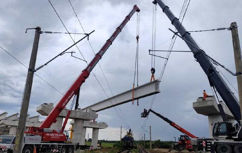 Cum se montează o grindă de 88 de tone peste liniile de înaltă tensiune ale căii ferate. Trei macarale participă la operațiunea de pe A7